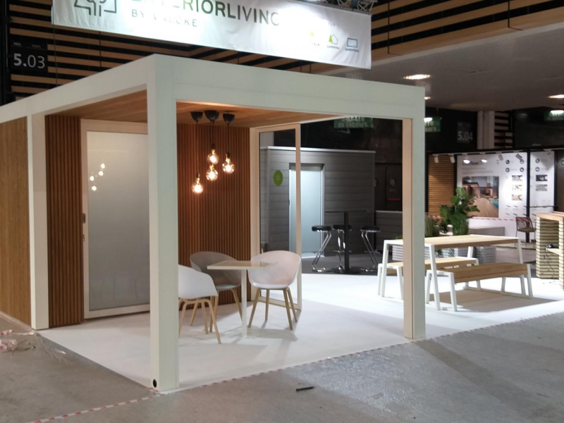 Studio de jardin blanc à bardage bois clair et baie dépolie sur stand d'exposition