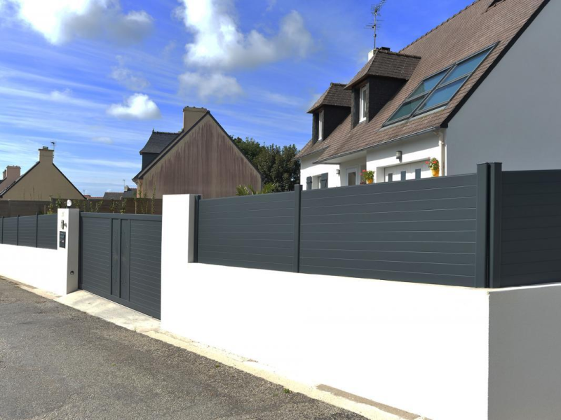 Clôture et portail anthracite à lames horizontales sur muret blanc devant maison