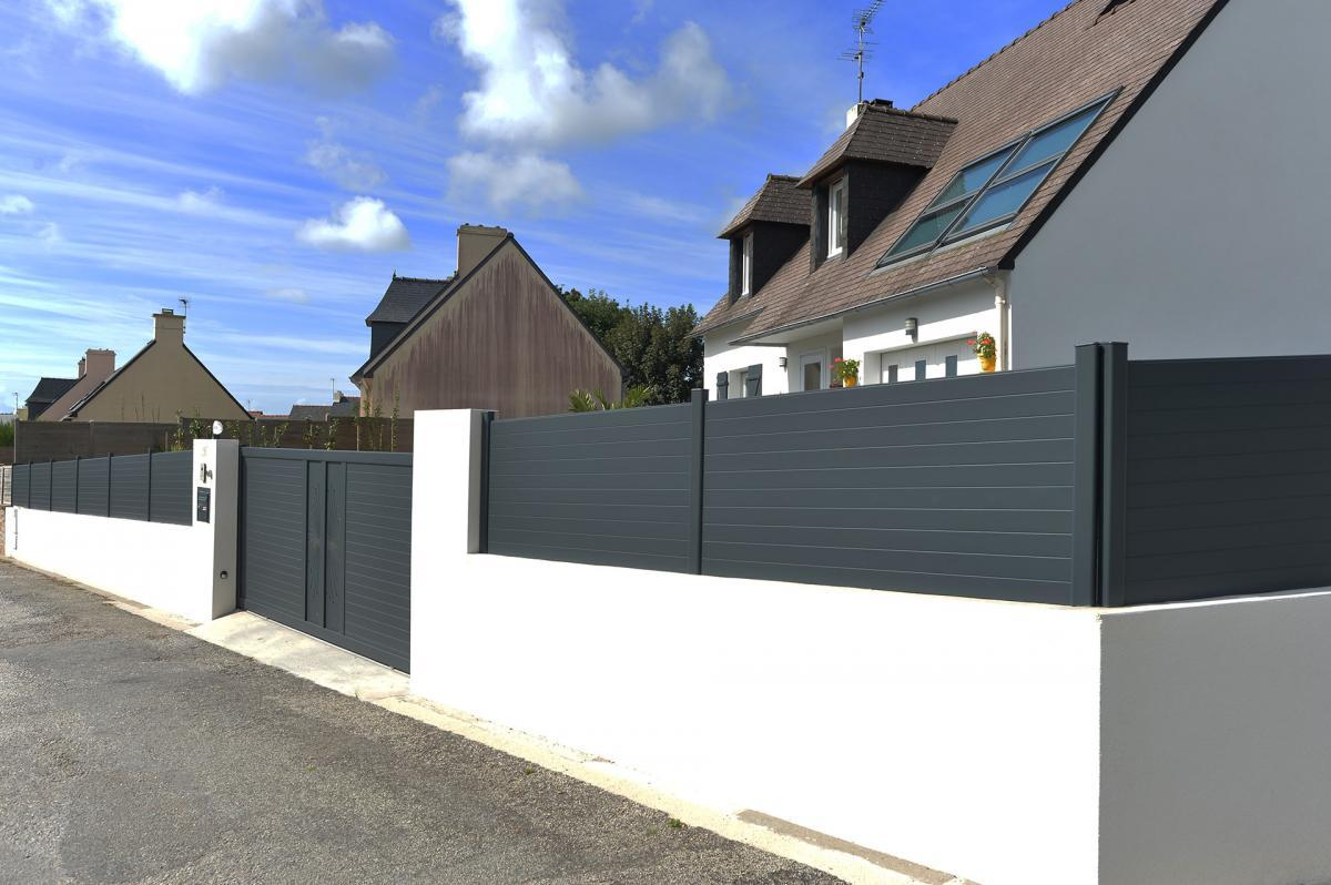 Clôture et portail anthracite à lames horizontales sur muret blanc devant maison