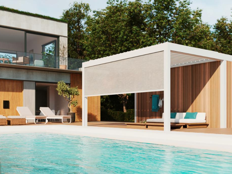 Pool house blanc à claustras bois et store gris au bord d'une piscine