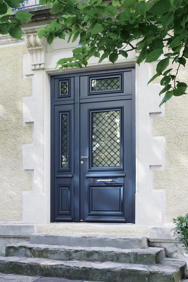 Porte d'entrée anthracite à vitrage décoratif et fixe latéral sur façade pierre