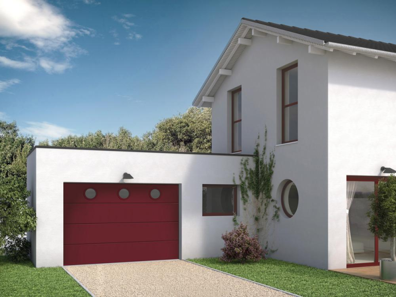 Porte de garage sectionnelle rouge bordeaux à hublots sur maison blanche
