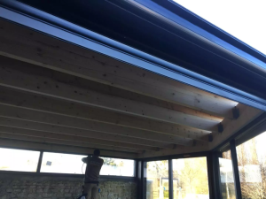 Extension d'un toit plat avec un bardage bois en clairevoie et en aluminium noir sablé à Caen