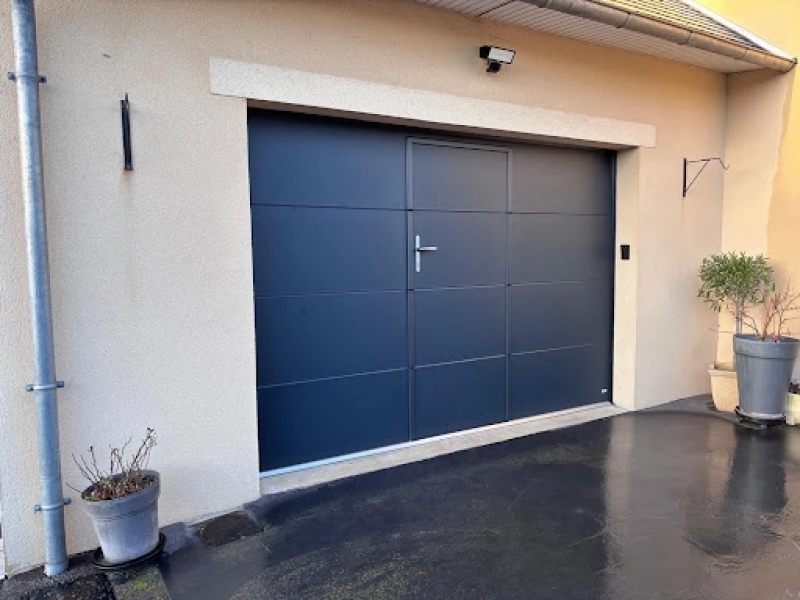 Installation d'une porte de garage sectionnelle avec portillon à Fleury-sur-Orne par Logikinov